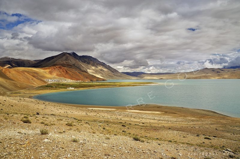 Lac de Tso Moriri en Himalaya, altitude 5000 m avec village au loin et montagne à 7000 m